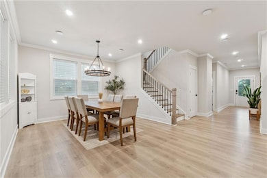 Dining area featuring stairs, light wood-style flooring, recessed lighting, crown molding, and baseboards