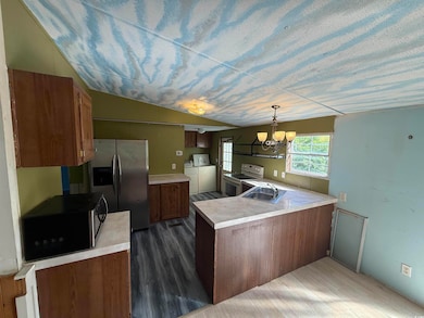 Kitchen with a notable chandelier, a peninsula, wh
