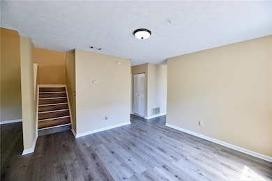 Unfurnished living room featuring wood finished fl