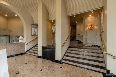 Staircase featuring arched walkways, granite finish floor, and baseboards
