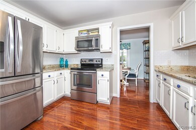 Kitchen with stainless appliances, white cabinetry
