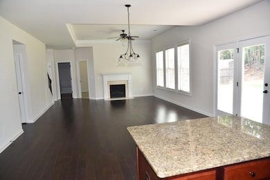 Unfurnished living room with a fireplace, dark wood-style flooring, ceiling fan, and ornamental molding