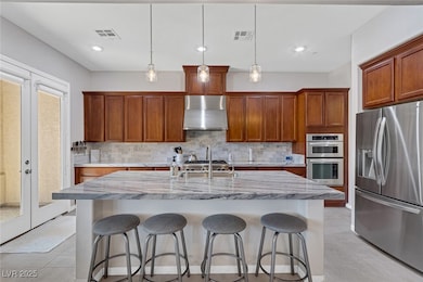 Kitchen with a breakfast bar area, stainless steel appliances, light tile patterned flooring, brown cabinets, and recessed lighting