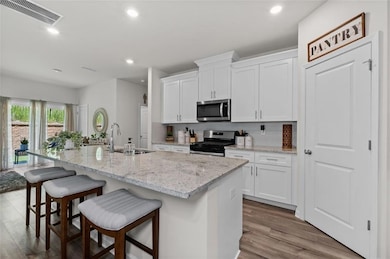 Kitchen featuring white cabinets, sink, stainless 