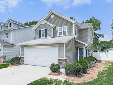 View of front of house with an attached garage, concrete driveway, and stone siding