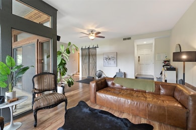 Living room with a barn door, wood finished floor