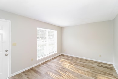 Spare room featuring light wood-style floors and baseboards