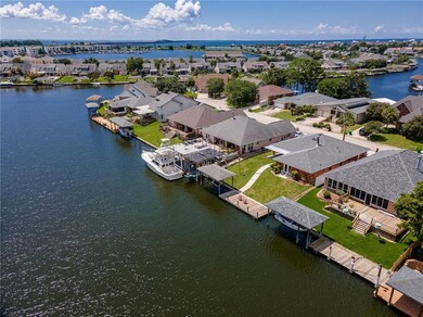 Looking for blue water in Lake Pontchartrain?  Here is an aerial view of the water ways.  The house is the second from the right, with two chairs on the dock.  Boat house with hoist, walkway to both.  Deep water canal.