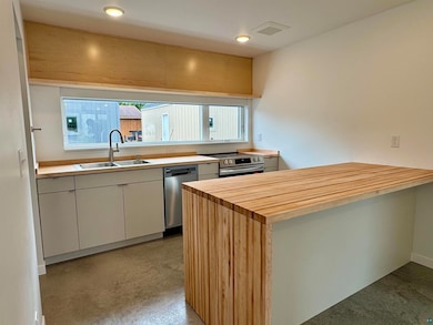 Kitchen with butcher block counters, stainless steel appliances, a peninsula, recessed lighting, and white cabinets