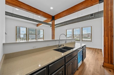Kitchen with light stone countertops, dishwasher, 