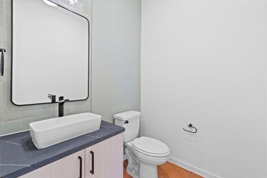 Bathroom with backsplash, toilet, vanity, and til