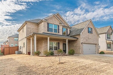 Craftsman-style house featuring an attached garage, brick siding, driveway, and a porch