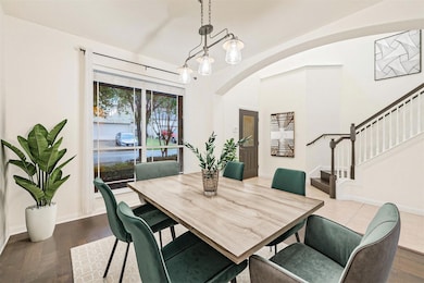 Dining room featuring arched walkways, stairs, da