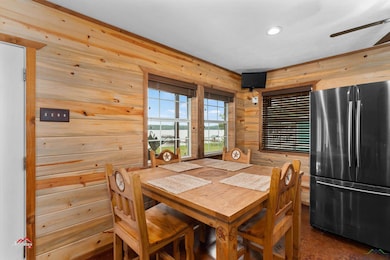 Dining room with wooden walls and ceiling fan