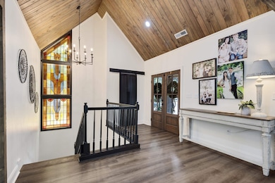 Foyer with high vaulted ceiling, wood finished floors, wooden ceiling, a chandelier, and recessed lighting