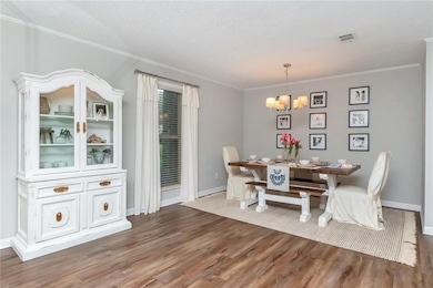 Dining space featuring a textured ceiling, crown m