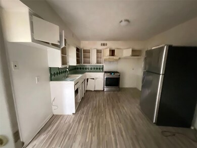 Kitchen with white cabinetry, light hardwood / woo