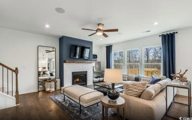 Living room with a ceiling fan, stairs, a fireplace, wood finished floors, and recessed lighting