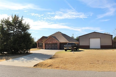 View of front facade with an outdoor structure, brick siding, and a detached garage