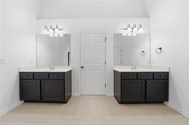 Bathroom featuring two vanities and light tile patterned flooring
