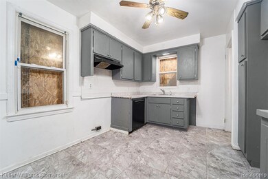 Kitchen featuring gray cabinets, backsplash, ceiling fan, under cabinet range hood, and black dishwasher