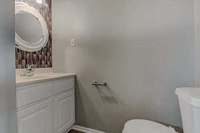 Bathroom featuring vanity, baseboards, and toilet
