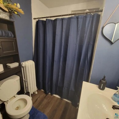 Bathroom featuring radiator heating unit, sink, ha