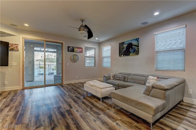 Living room featuring a ceiling fan, wood finished