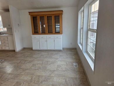 Unfurnished dining area featuring baseboards and light stone finish flooring