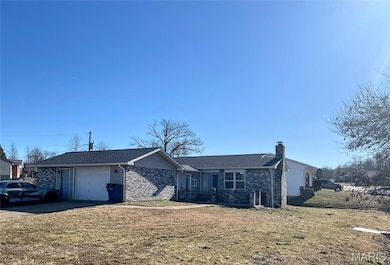 Ranch-style house with brick siding, an attached garage, a chimney, and concrete driveway