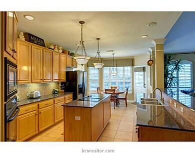 Kitchen. The gourmet kitchen offers beautiful tile flooring, custom cabinetry, and plenty of storage space.