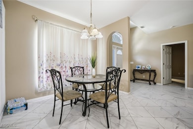 Dining space with marble look tiles and a chandelier