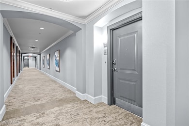 Hallway with carpet flooring and crown molding