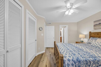 Bedroom featuring crown molding, light wood-type f