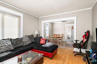 Living area featuring ornamental molding, hardwood