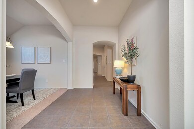 Corridor with lofted ceiling and light tile patter