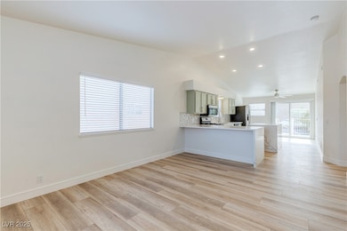 Kitchen featuring vaulted ceiling, light counterto