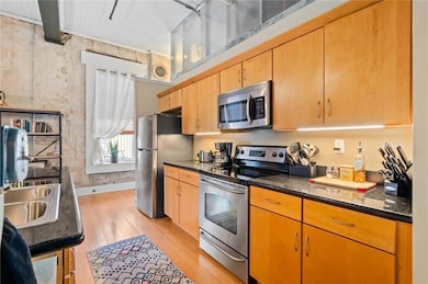 Kitchen with sink, granite countertops, and applia
