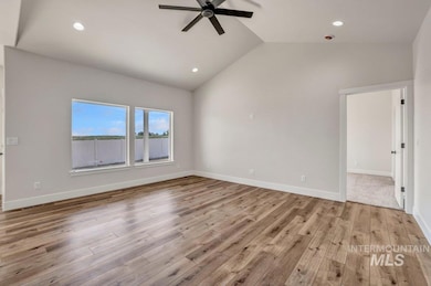 Unfurnished room with a ceiling fan, lofted ceiling, wood finished floors, and recessed lighting