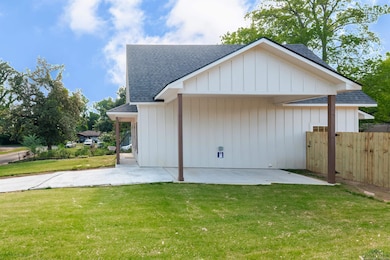View of property exterior with a shingled roof and a patio