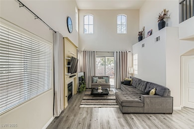 Living area with wood finished floors, a towering