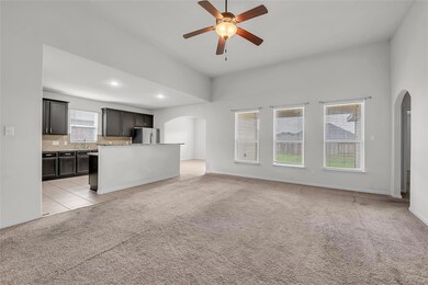 Unfurnished living room featuring arched walkways