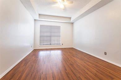 Empty room featuring a raised ceiling, ceiling fan