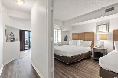 Bedroom with a textured ceiling and hardwood / woo