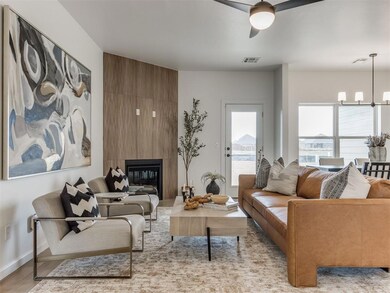 Living room with a large fireplace, ceiling fan wi
