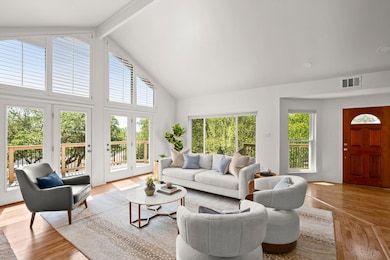 Living room featuring beam ceiling, high vaulted ceiling, and light wood-type flooring