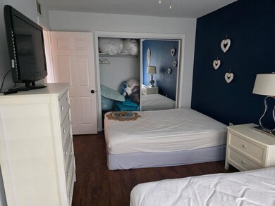 Bedroom with wood finished floors and a closet