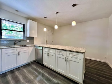 Kitchen with stainless steel dishwasher, a sink, 