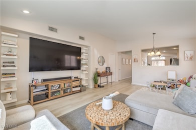 Living room with recessed lighting, a chandelier,
