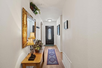 Doorway with a textured ceiling, visible vents, b